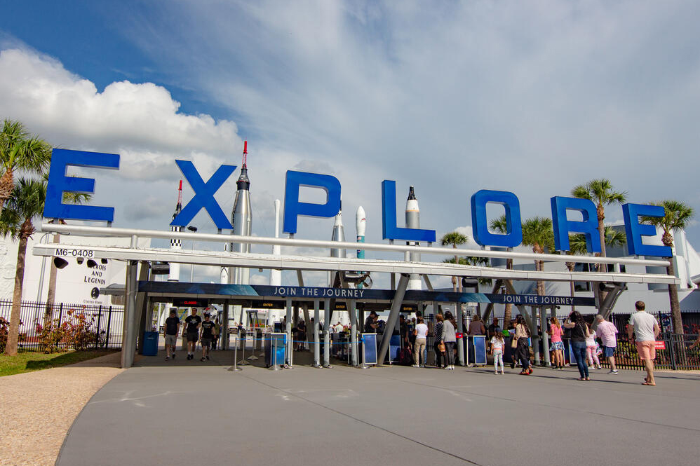 Entrance to space exhibit with rockets and people.
