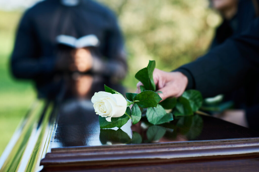 White rose on coffin at funeral service