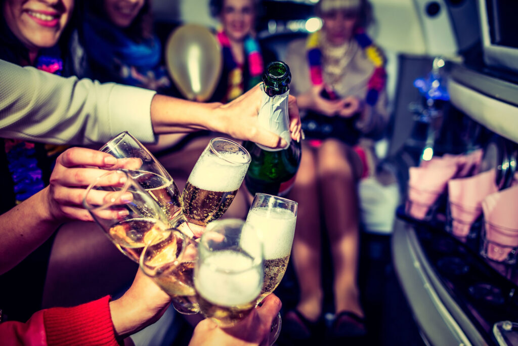 People celebrating with champagne in a limousine.