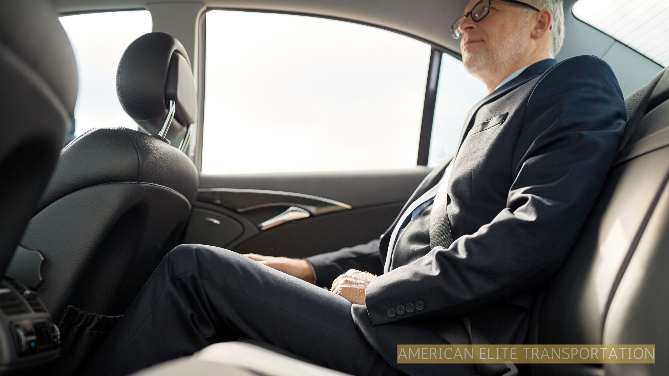 Man relaxing in the back seat of a chauffeured luxury car during a professional limo service ride.